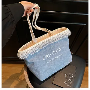Close-up of denim tote bag with white lace trim and minimalist printed graphic text