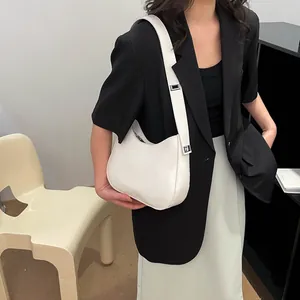 Minimalistische witte leren hobo-tas met verstelbare zilveren gesp aan de schouderriem