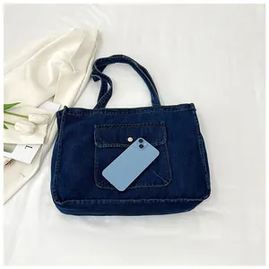 Detailansicht der dunkelblauen Denim-Einkaufstasche mit Goldknopf-Tasche und Smartphone-Größe