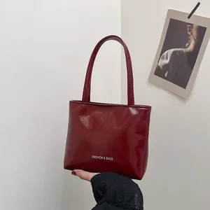 Dettaglio della borsa bordeaux in ecopelle lucida con il logo Fashion & Bags stampato