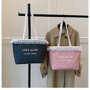 Detail of lace-trimmed denim tote bags in pink and black colors with broad straps