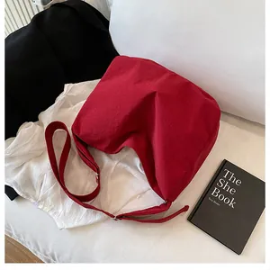Detail of red wide-strap crossbody bag in lightweight nylon fabric with adjustable buckle