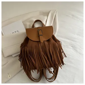 Detailed view of the brown vintage tassel backpack featuring a leather flap and suede texture