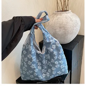 Dettaglio della borsa in pizzo azzurro con texture floreale in rilievo 3D