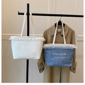 Detail of lace trim and Evea Glow lettering on denim and canvas tote bags for women