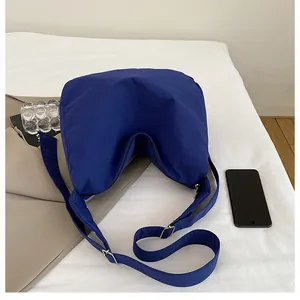 Macro shot of dark blue nylon crescent bag featuring adjustable wide shoulder strap details