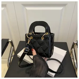 Detailed close-up of a black quilted leather mini handbag with gold hardware details
