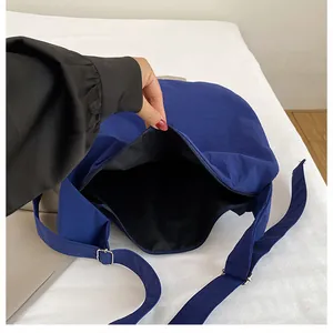 Detail of navy blue crossbody tote showing zipper closure and spacious interior lining