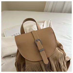 Close-up of khaki fringe backpack with matte texture and decorative metal buckle