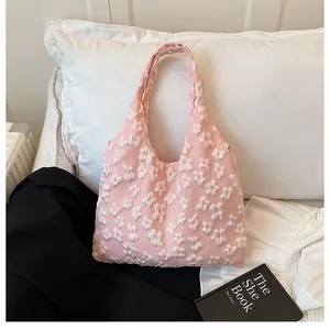 Dettaglio borsa tote rosa con fiori 3D bianchi e trama di tessuto morbido