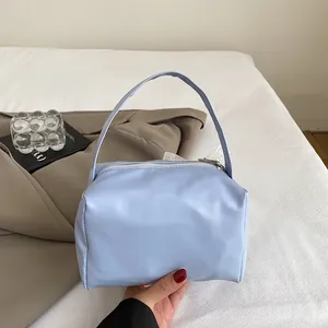 Detail of light blue mini handbag featuring soft PU leather texture and metal zipper