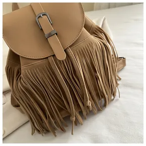Detail of camel suede texture and fringe design on vintage style backpack with metal buckle