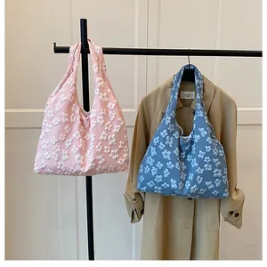 Dettaglio di borse tote in pizzo floreale rosa e blu con motivi floreali in 3D