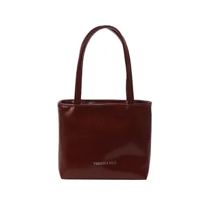 Borsa a mano minimalista rosso vino lucido con finitura verniciata e logo argento