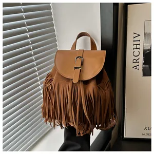 Detail view of brown tassel backpack with metal buckle and matte suede texture finish