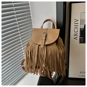 Close-up of vintage camel fringe backpack featuring suede texture and decorative tassels