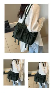 Détail du sac fourre-tout vert foncé avec nœud et plis de serrage sur la bandoulière