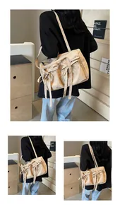 Détail du sac cabas beige avec des nœuds rubans doux et une texture de tissu plissé