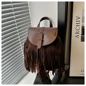 Detail of dark brown vintage tassel backpack with suede texture and metal buckle closure