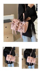 Détail d'un sac à bandoulière rose clair avec de gros nœuds et une texture plissée