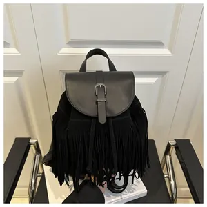 Detail of a black tassel backpack with drawstring closure and metal buckle on the leather flap