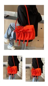 Détail du sac cabas en nylon orange avec nœuds en ruban et fermeture éclair en métal argenté
