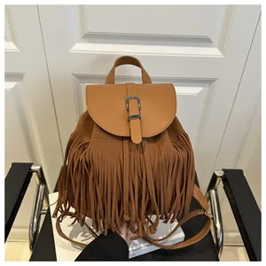 Detail view of brown faux suede fringe backpack with buckle strap and bohemian tassels