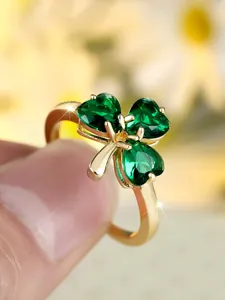 Detailed close-up of emerald clover ring featuring heart-shaped stones and gold plating