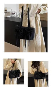 Détail d'un sac cabas en nylon noir avec de grands nœuds et un intérieur spacieux