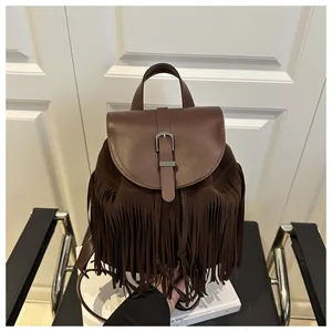 Detailed view of vintage dark brown backpack with fringe tassels and metal buckle