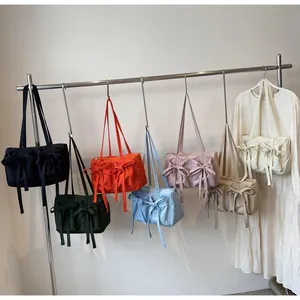 Vue détaillée de sacs cabas colorés avec nœuds suspendus sur un support métallique