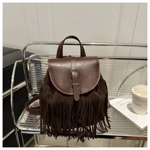 Vintage brown leather backpack with bohemian tassels and metallic buckle in a casual setting