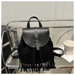 Detail of vintage black fringe backpack with smooth leather flap and suede texture