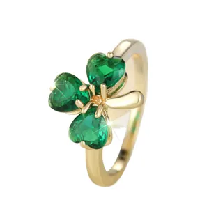 Elegant gold clover ring featuring three green heart gemstones on a clean white background