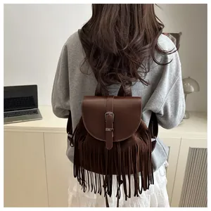 Close-up of vintage brown tassel backpack featuring smooth leather flap and suede texture