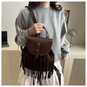 Detail shot of vintage dark brown backpack with fringe tassels and buckle flap cover