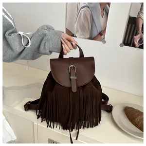 Detail of vintage brown tassel backpack featuring matte faux leather and metal buckle closure