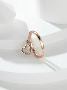 Dettaglio dell'anello a cuore in oro rosa con pavé di zirconi e ciondolo appeso
