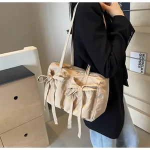 Détail du sac cabas beige avec grandes poches et jolis nœuds décoratifs