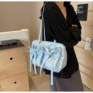 Détail du sac cabas bleu clair avec deux nœuds décoratifs et fermeture à glissière