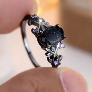 Macro shot of dark vine ring with oval blue sandstone and purple zircon accents