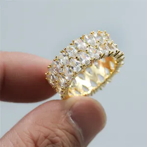 Close-up of triple row gold ring featuring pave-set pear-cut clear cubic zirconia stones