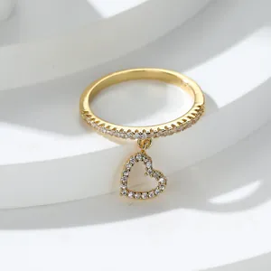 Elegante anello con ciondolo a cuore dorato e zirconi bianchi lucidi su base bianca