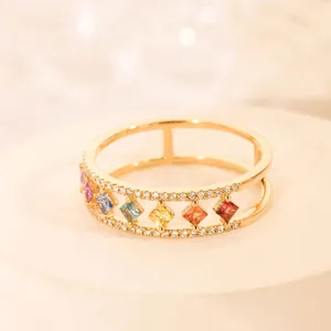 Dubbellaagse gouden ring met kleurrijke zirkonia-stenen op een ronde stenen sokkel