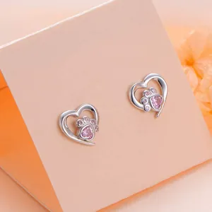 Silver heart stud earrings with pink zircon pet paw print on a soft pink display
