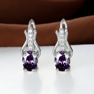 Makroaufnahme ovaler violetter Kristallohrringe mit silbernem Verschluss und Diamanten