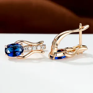 Elegante goldene Ohrringe mit ovalen blauen Kristallen und weißen Zirkonia-Akzenten