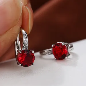 Dettaglio macro di orecchini in argento con zircone rosso e accenti di diamanti