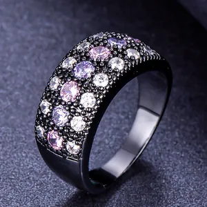 Close-up of a wide black band ring pavé-set with pink, purple, and white cubic zirconia