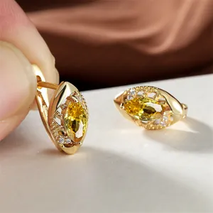 Détail de boucles d'oreilles en or avec zircon jaune marquise et cristaux sur soie